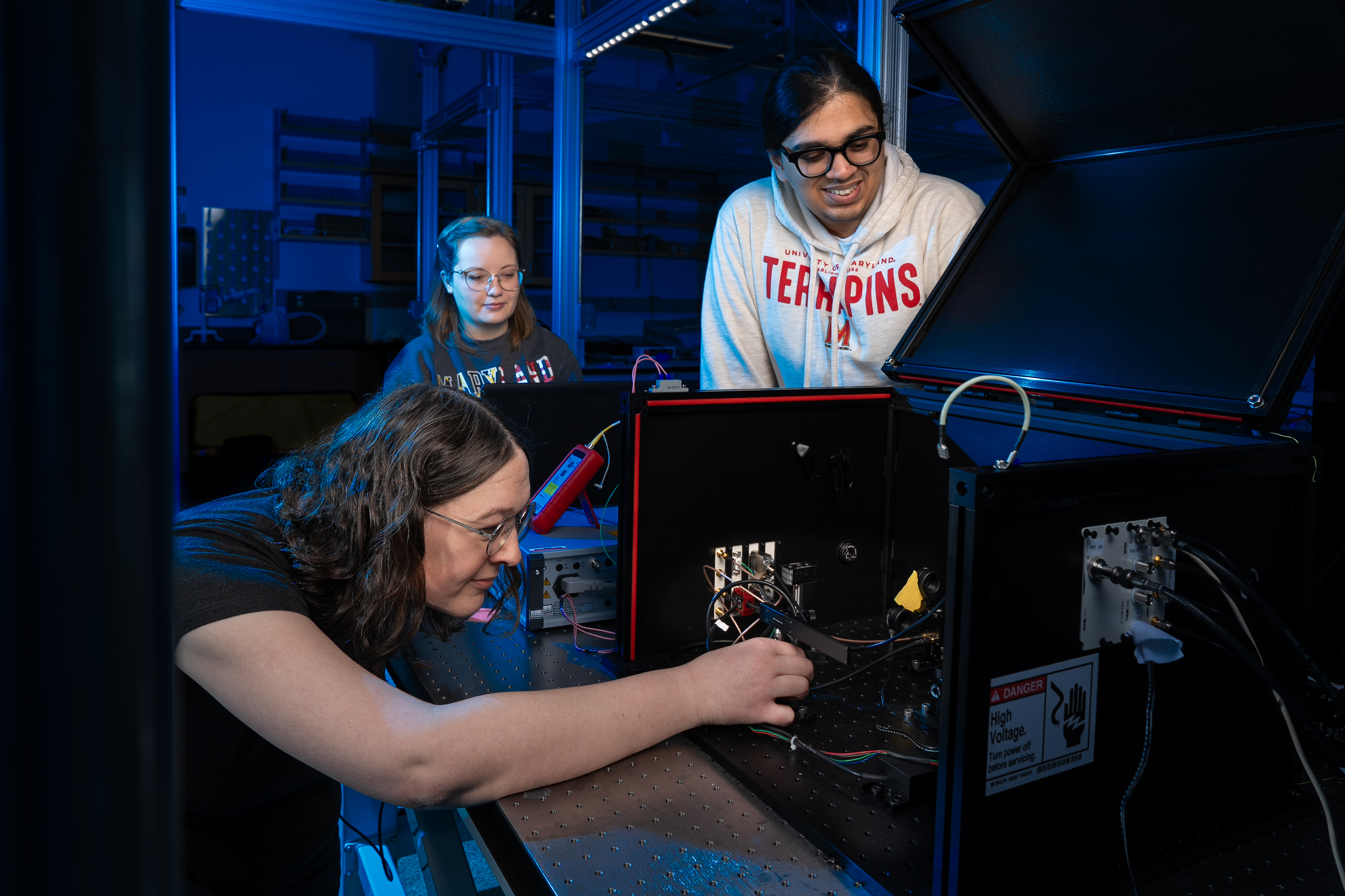 Phoebe Hamilton, Elizabeth Kowalczyk and Othello Gomes check a photodetector.