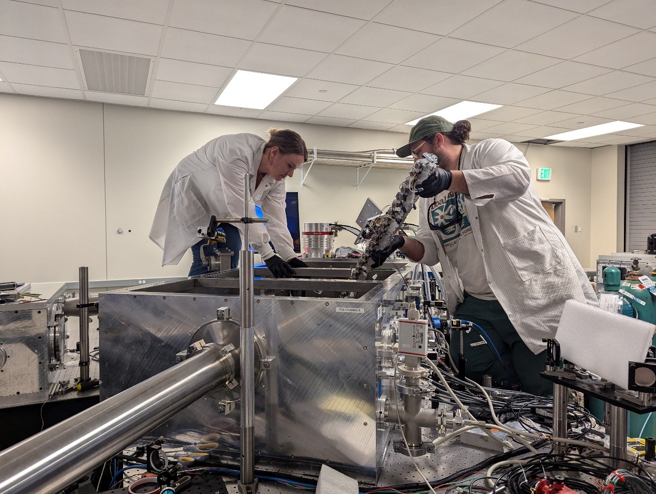 Shrock (right) with Ela Rockafellow (left) installing a prototype 1 meter gas jet on the ALEPH laser system at Colorado State University.