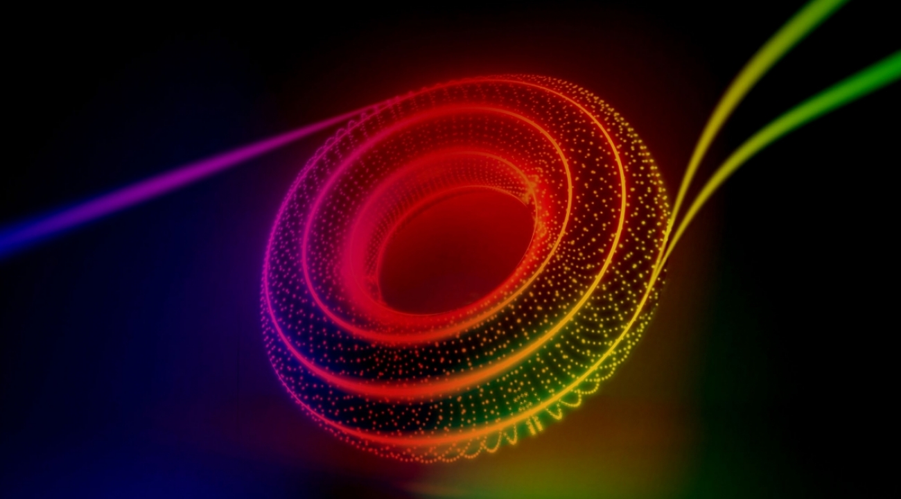 A new technique sees two distinct particles of light enter a chip and two identical twin particles of light leave it. The image artistically combines the journey of twin particles of light along the outer edge of a checkerboard of rings with the abstract shape of its topological underpinnings. (Credit: Kaveh Haerian)